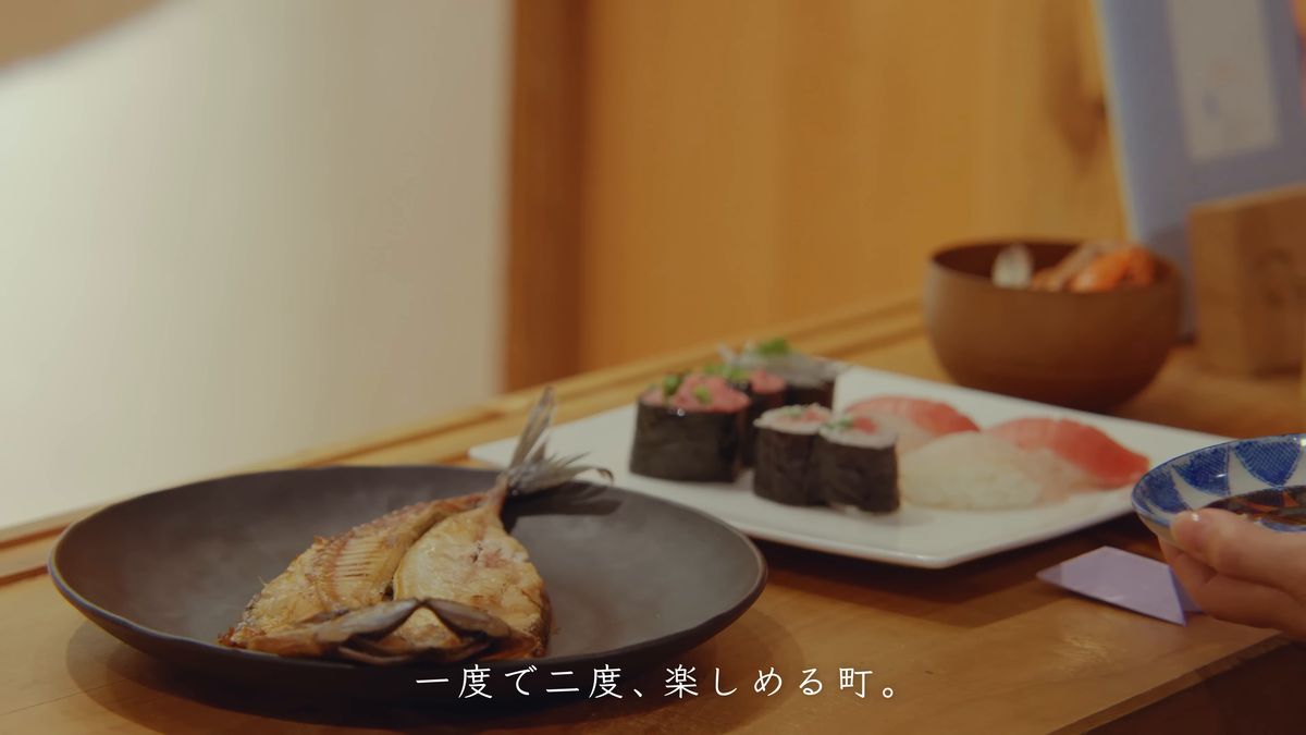 焼いたアジの開きと寿司の皿