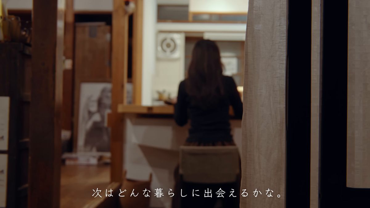 廊下から見た、台所のカウンターに向かう後ろ姿