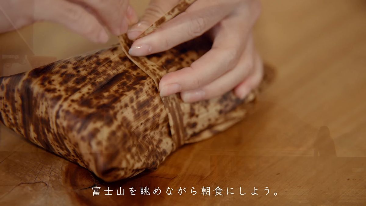 竹皮の包みを紐で結ぶ手元