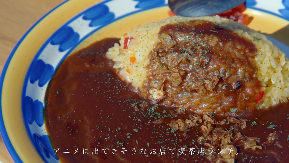 黄色いピラフにかかった茶色いソースと揚げ玉ねぎ