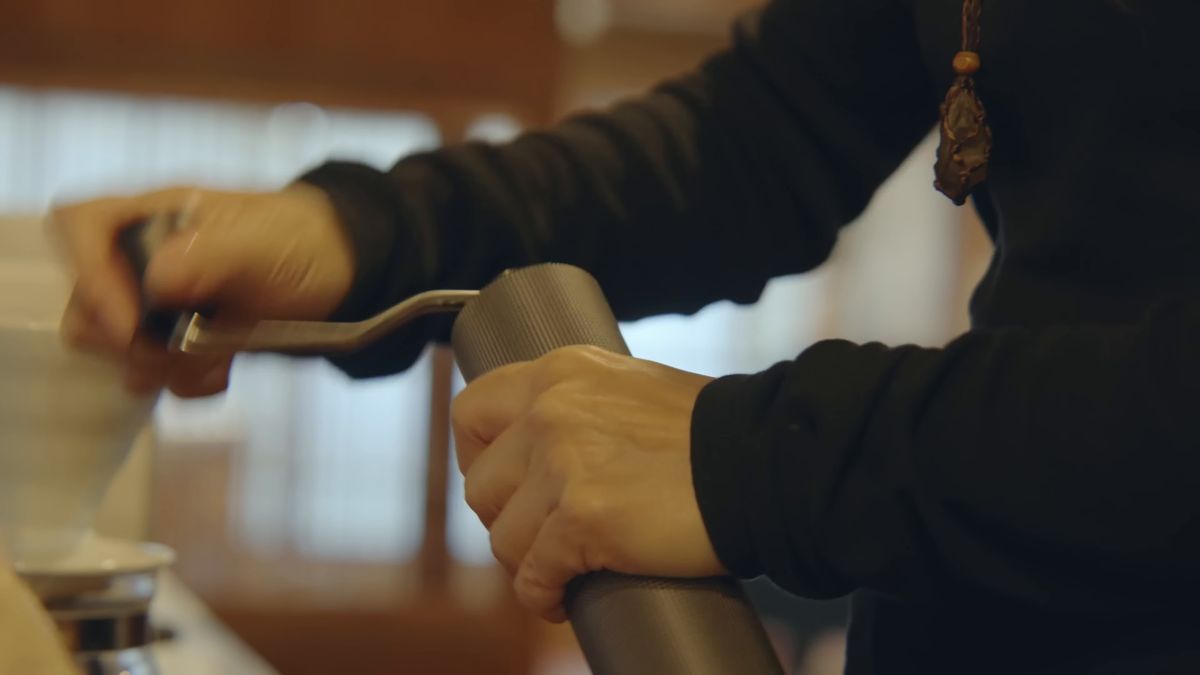手回しのコーヒーミルを回す手元