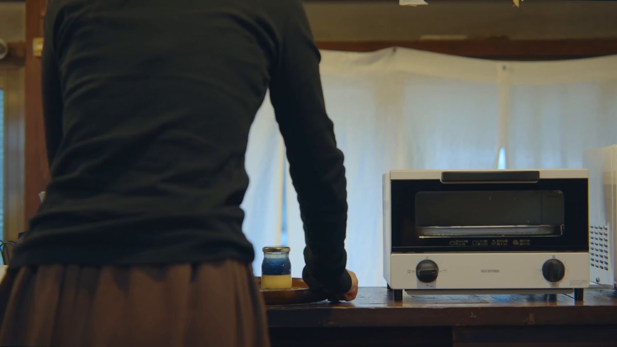トースターの前に立つ後ろ姿