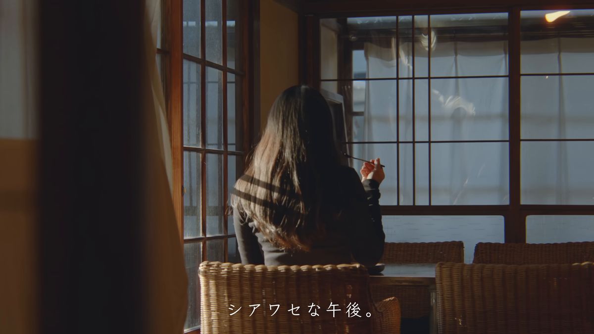 窓辺の籐の椅子に座る後ろ姿