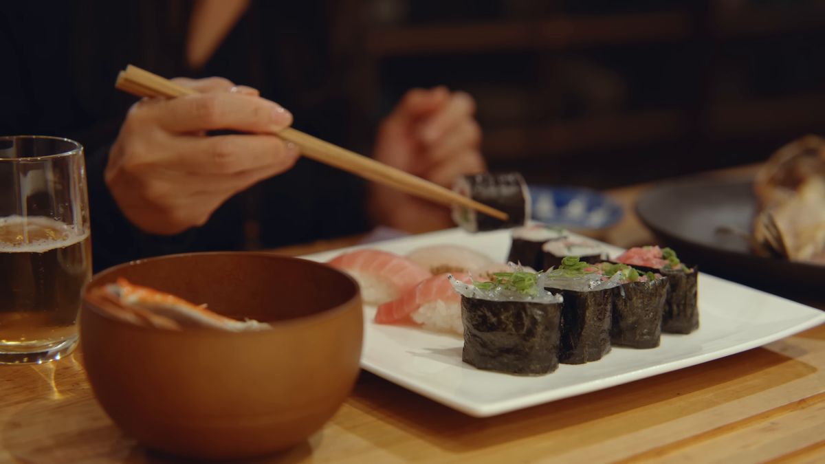 箸で寿司を取る