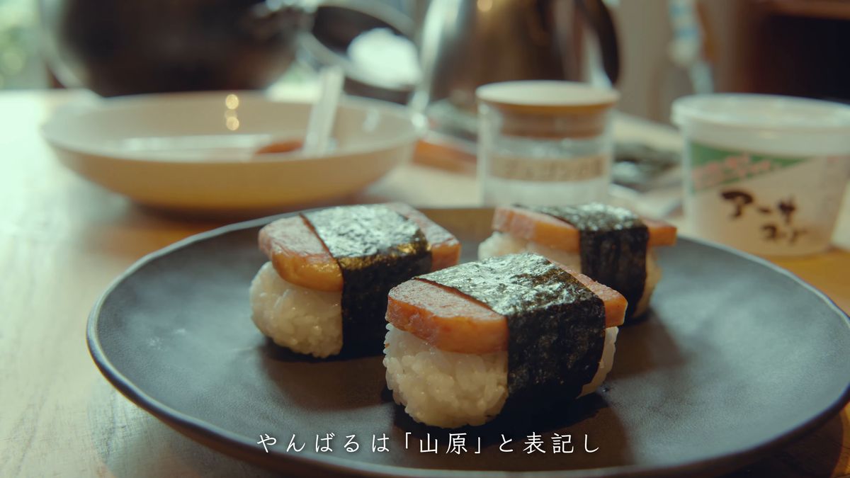 Spam musubi lined up on a black plate