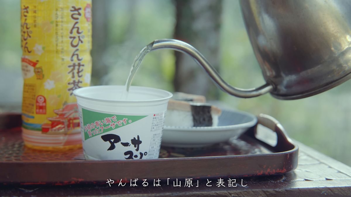 A bottle of sanpin tea and hot water poured into a cup of aasa soup