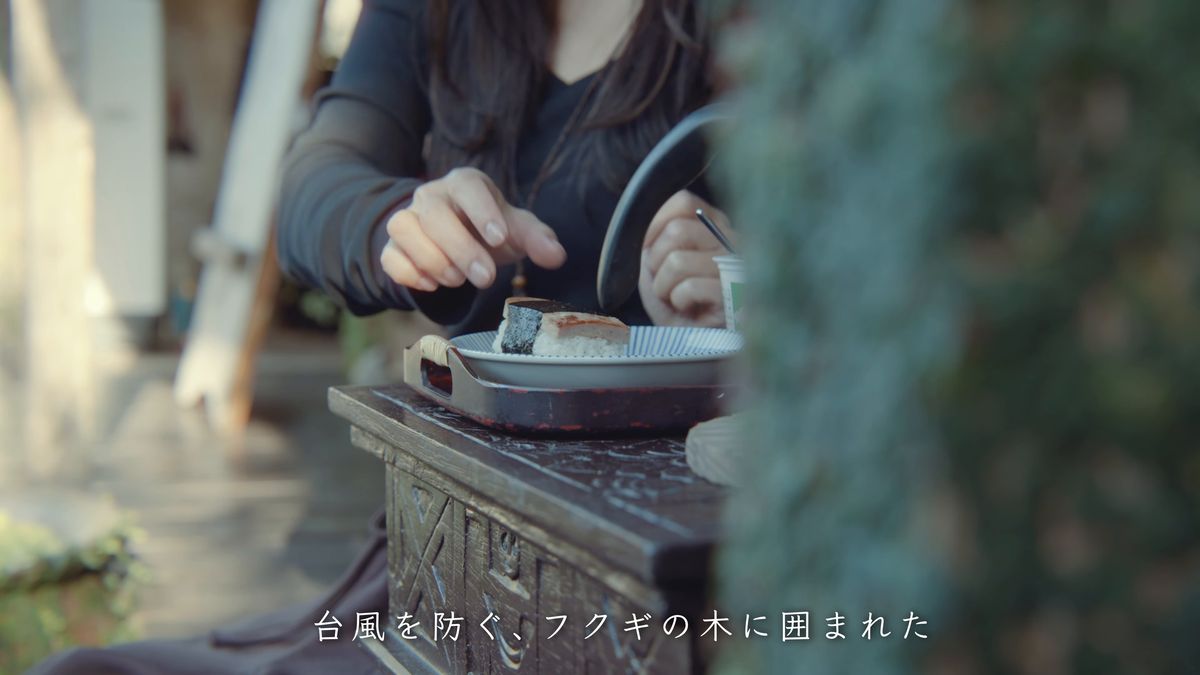 Eating a rice ball at a small table on the veranda