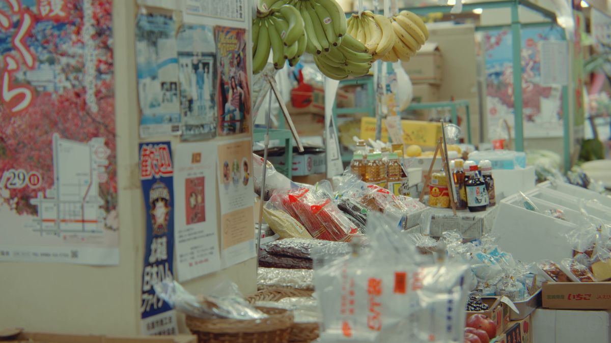 A market stall with bunches of bananas and posters