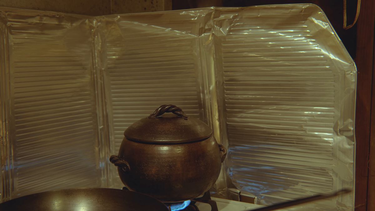A black clay pot on the gas stove