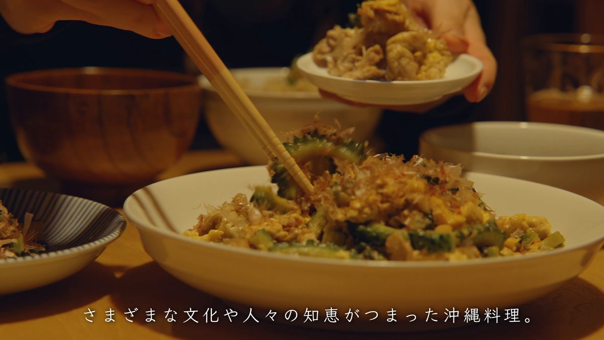 Bringing chanpuru topped with bonito flakes to the table