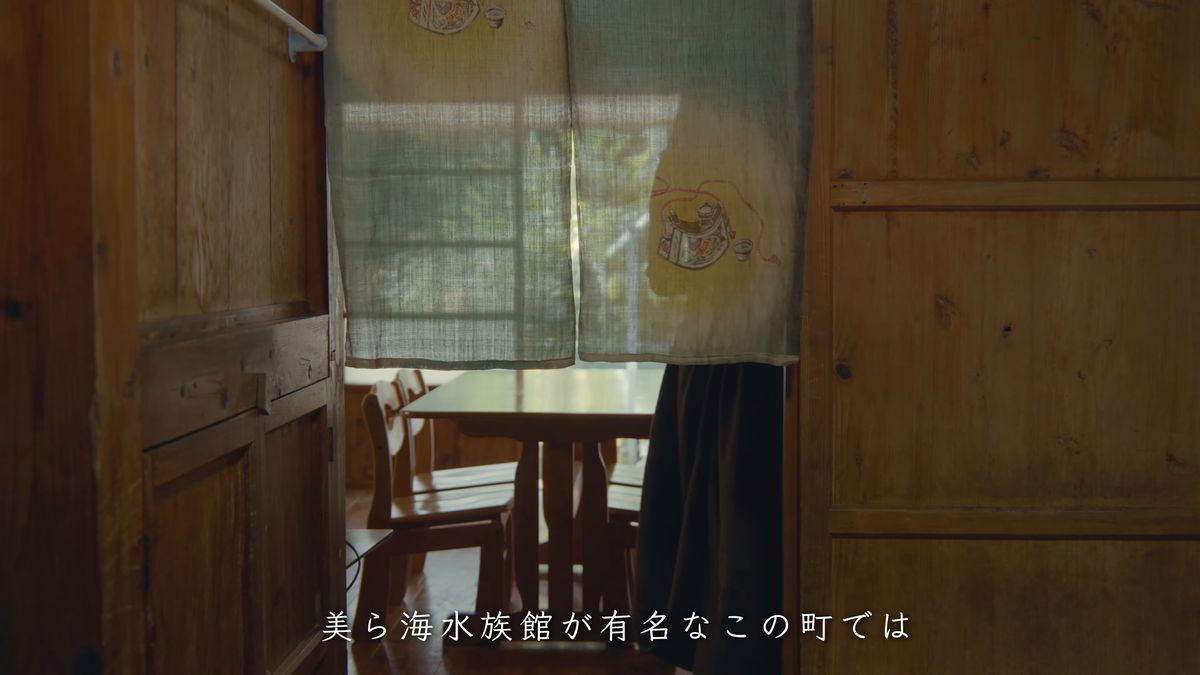 のれんの向こうに見える木の食卓