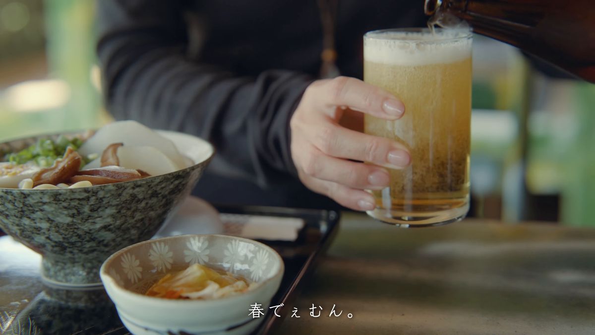 沖縄そばの横でグラスを手にする