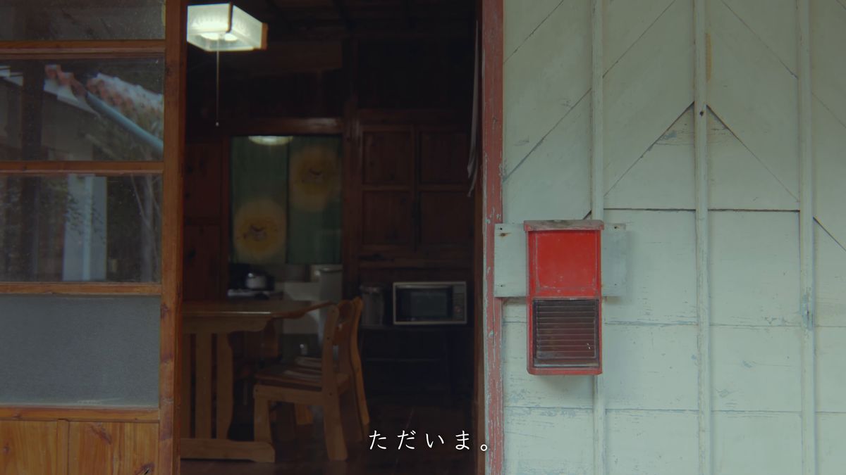 明かりの灯った台所と白い板壁