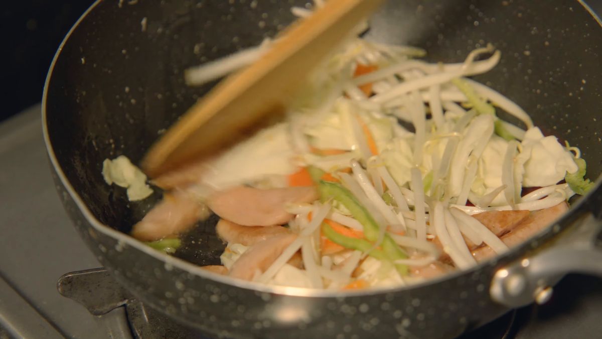 鍋で炒めるキャベツともやしと薄切りの肉