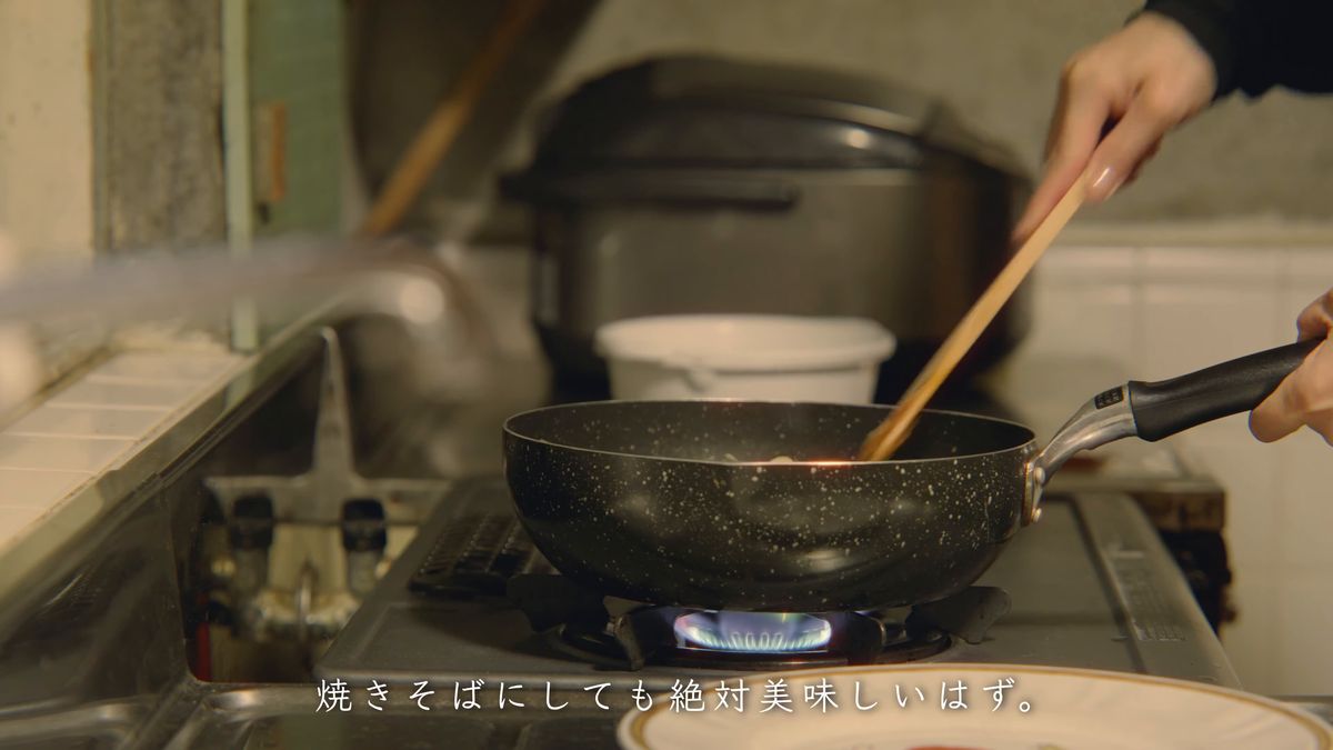 ガスの火にかけた鍋を木べらで混ぜる