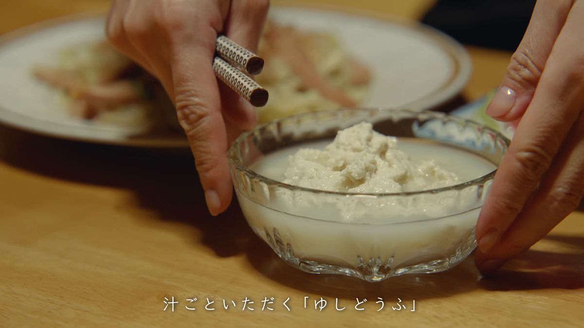 ガラスの器に盛ったゆし豆腐を運ぶ手元