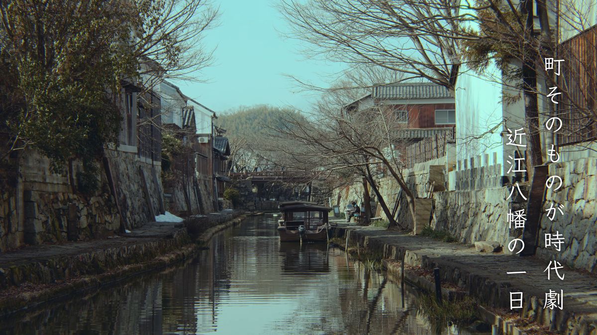 白壁の土蔵が並ぶ八幡堀を行く屋根つきの舟