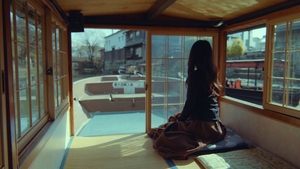畳敷きの舟の中に座る後ろ姿