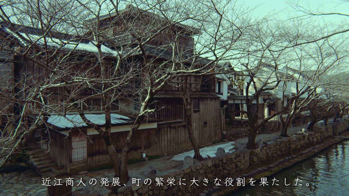 水面に枝を伸ばす桜の木と土蔵
