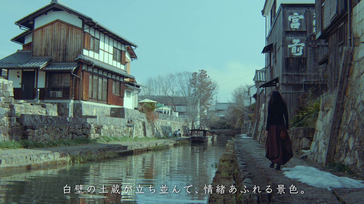 土蔵の前の石畳を歩く後ろ姿