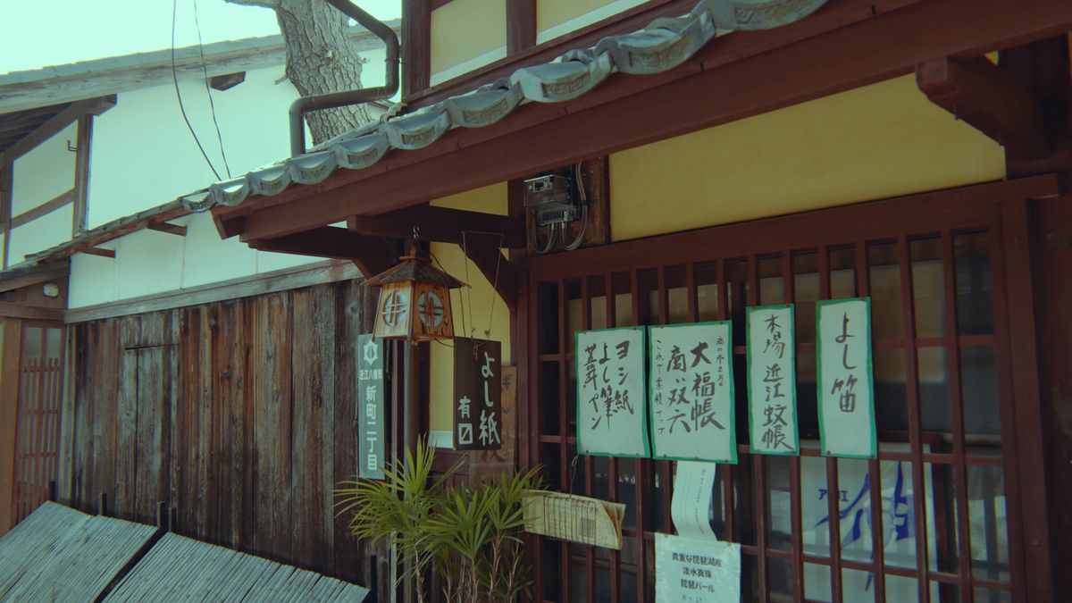 よし笛や近江蚊帳の貼り紙が並ぶ格子窓