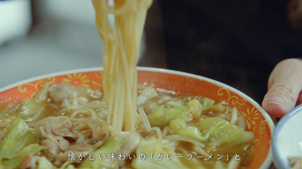 カレーラーメンの麺を箸で持ち上げる