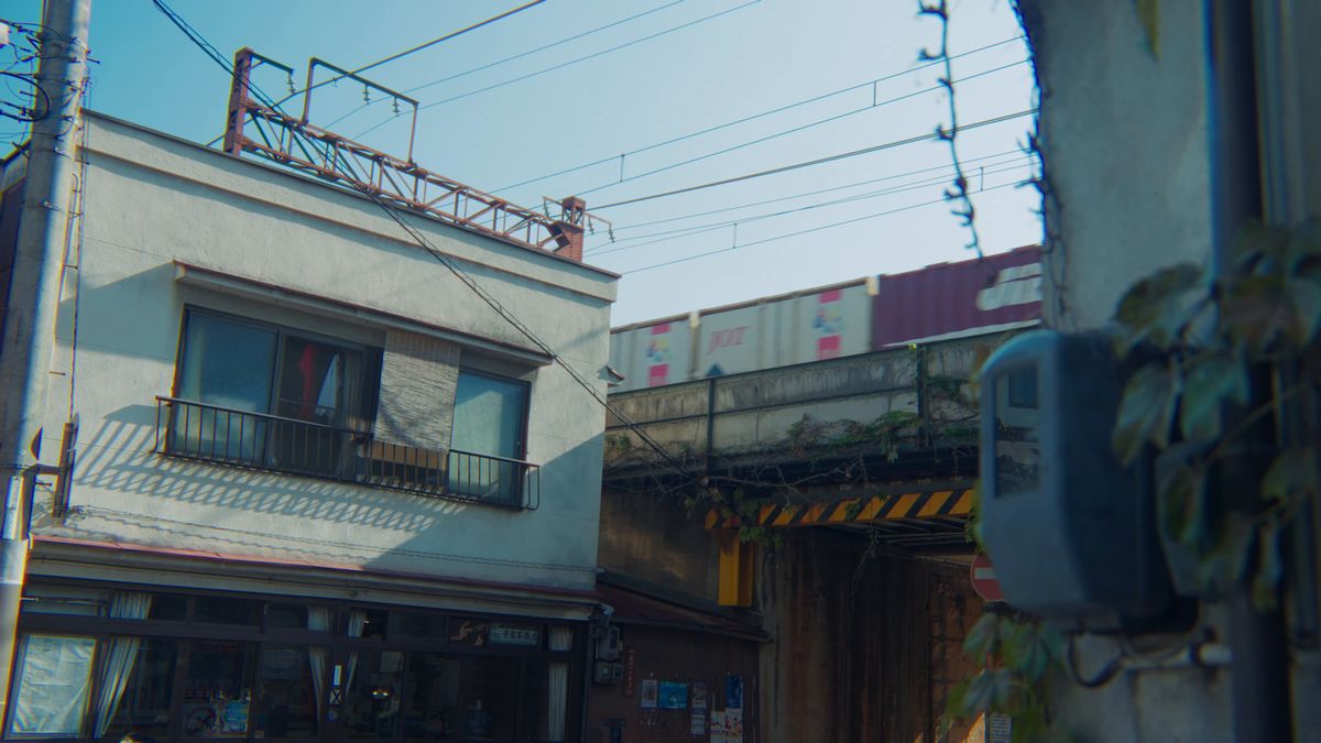 高架を渡る貨物列車と街角の建物