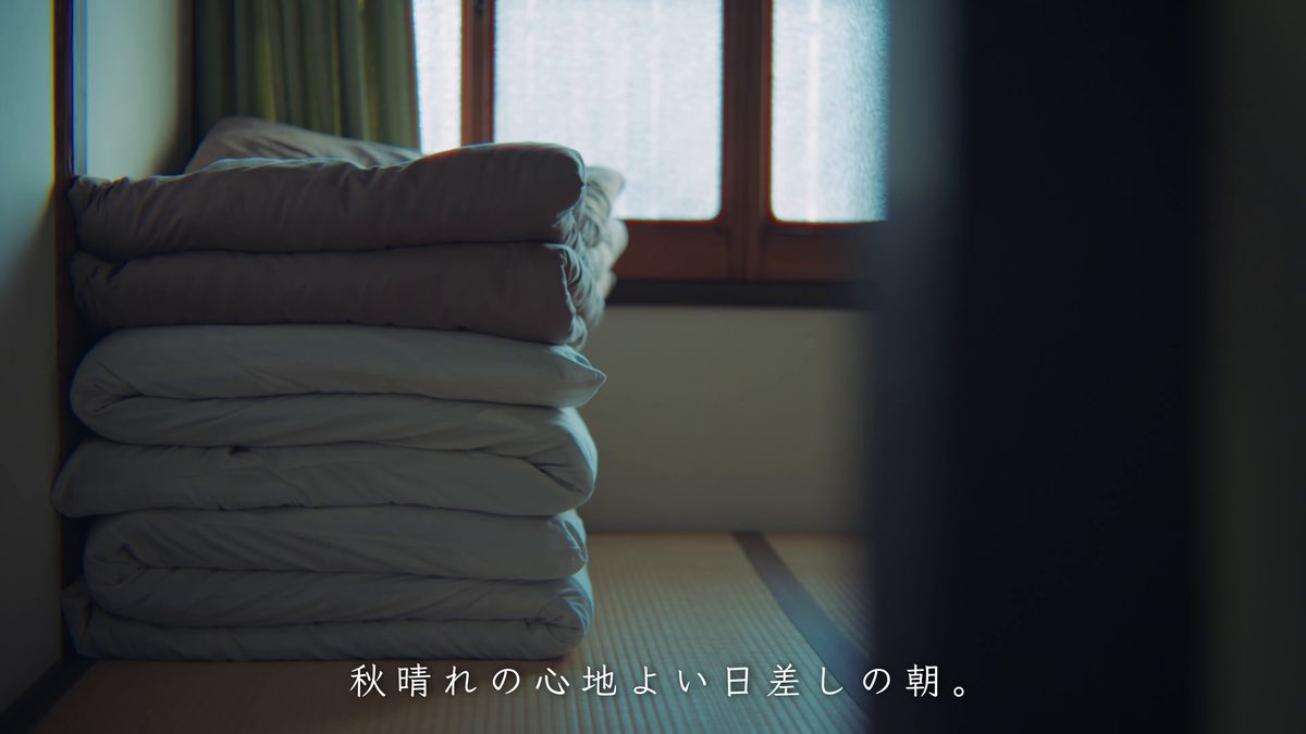 窓辺に畳んで重ねた布団