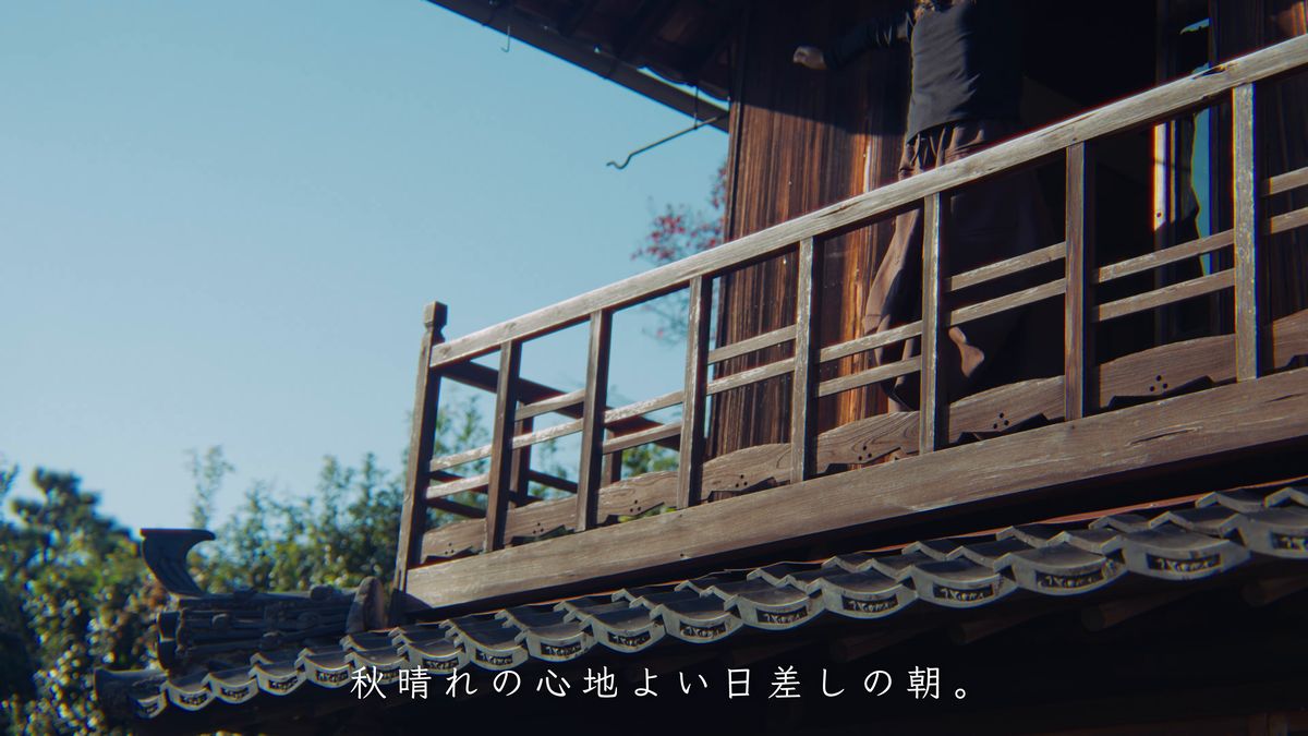 青空の下、二階の木の手すりと瓦屋根