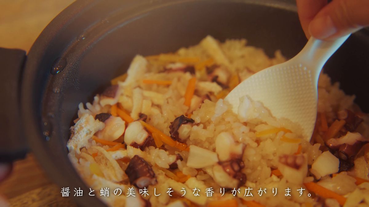 炊き上がったタコ飯をしゃもじで混ぜる