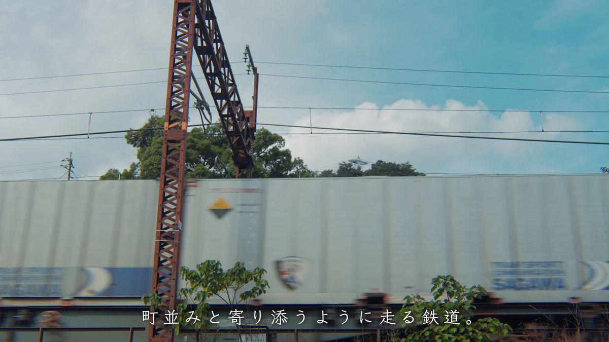 鉄塔の脇を通る貨物列車のコンテナ