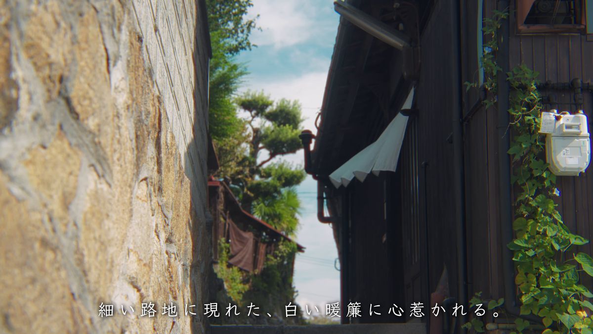 石垣の細い路地の先の白い暖簾