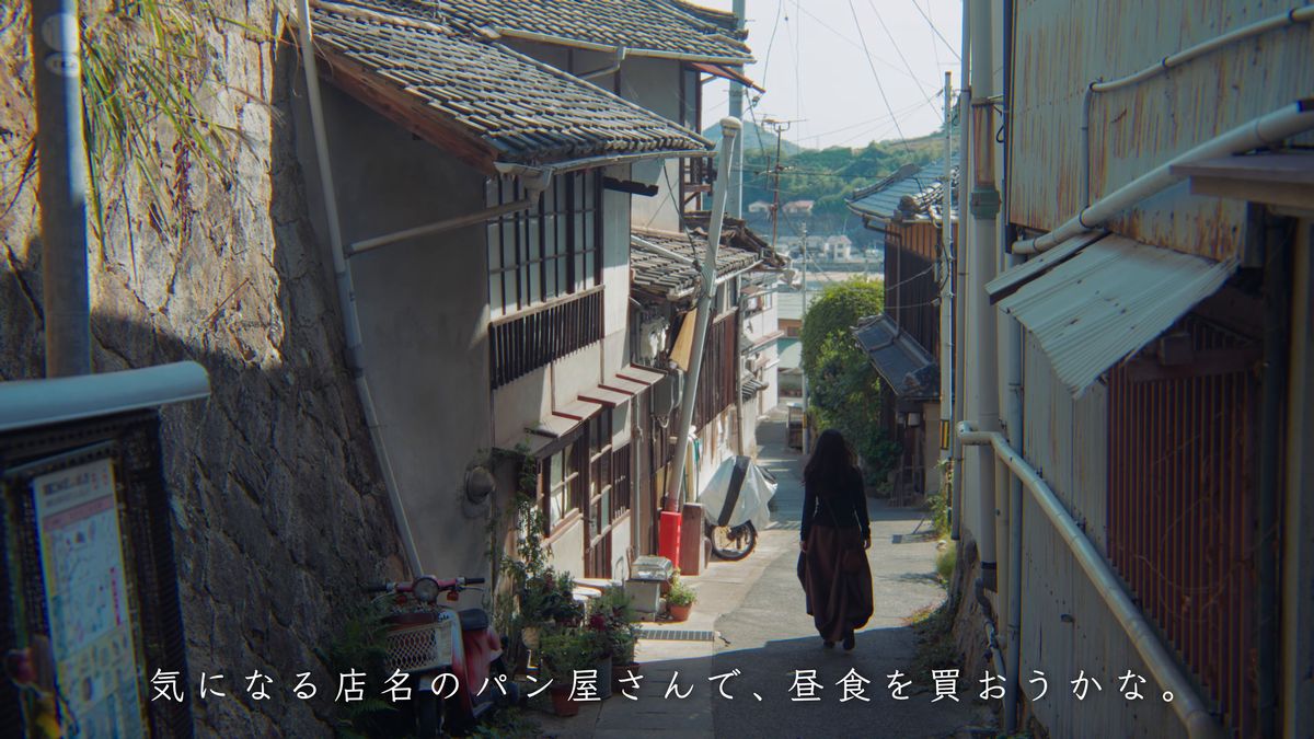 白壁と石垣の路地を歩く後ろ姿