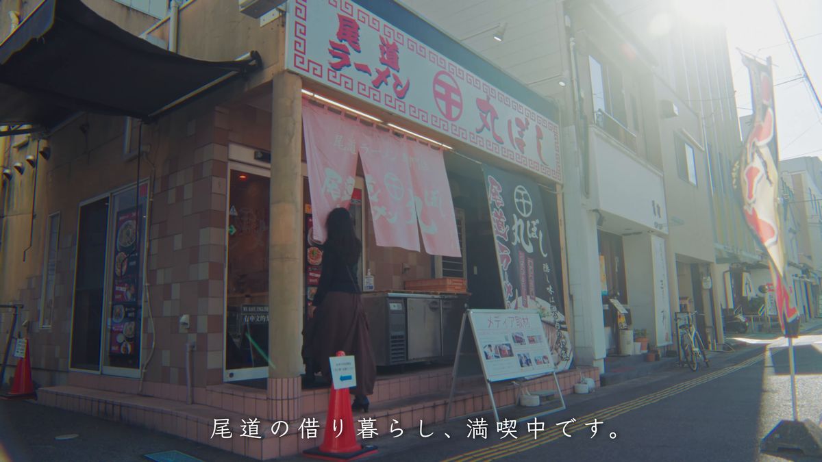 ラーメン店の前を通る後ろ姿
