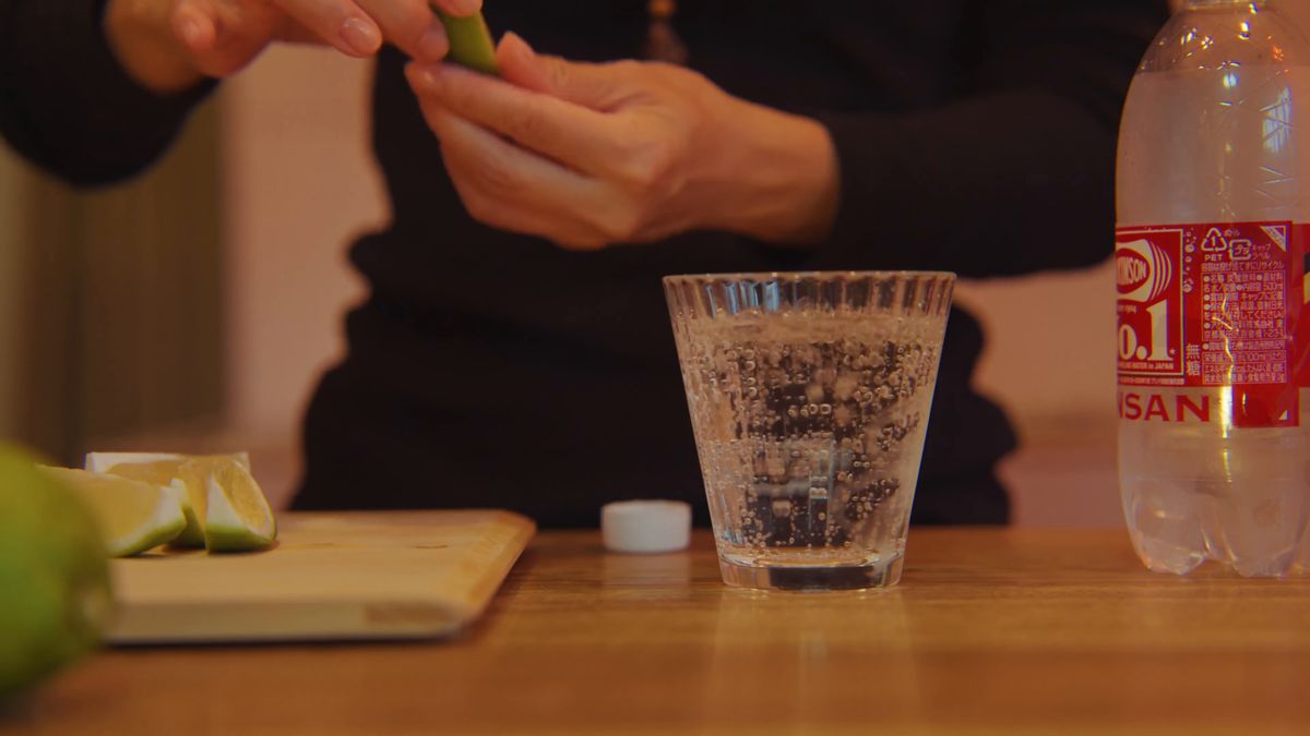 くし切りのレモンをグラスに搾る手元