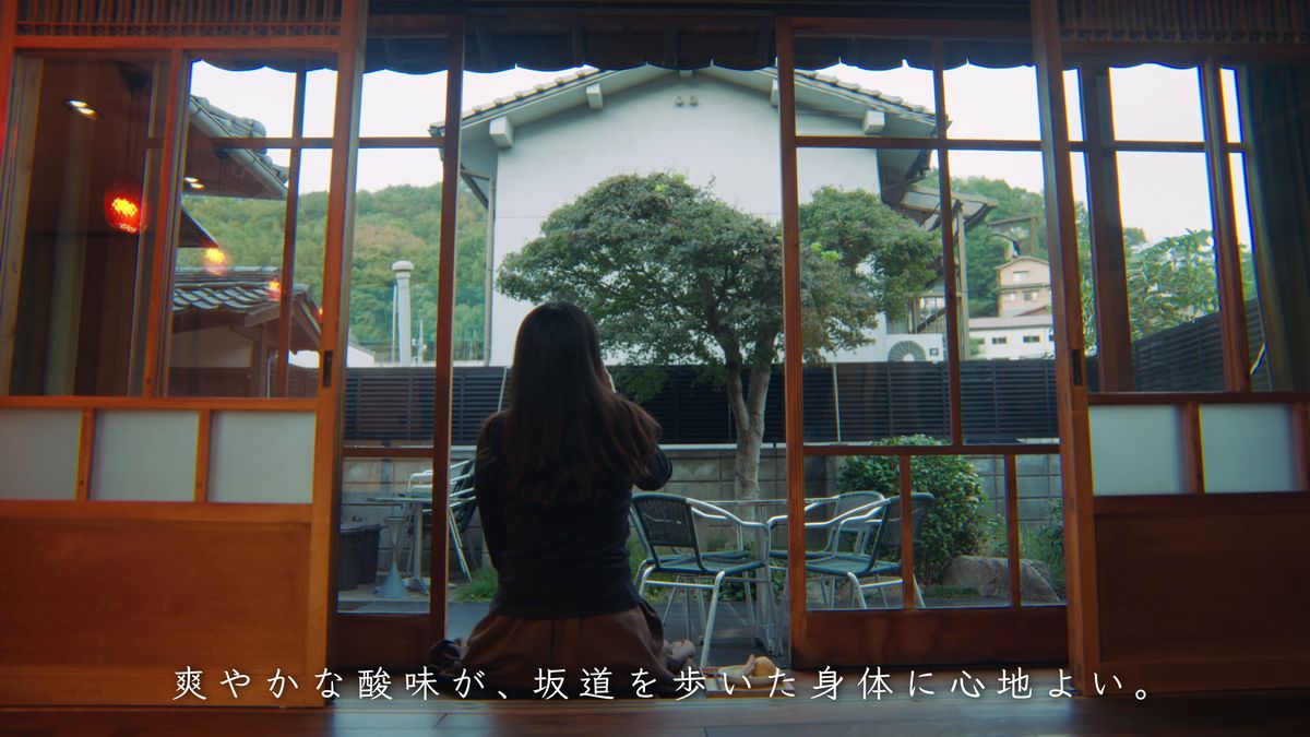 窓辺に座って庭を眺める後ろ姿