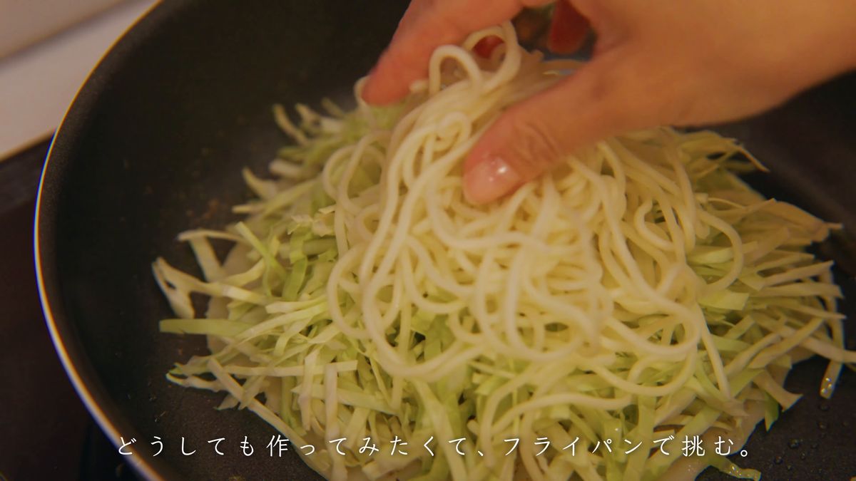 生地の上にキャベツと麺を手でのせる