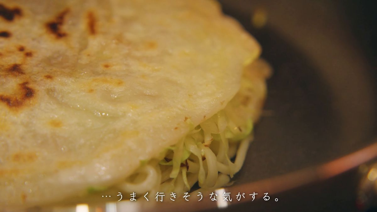 生地の縁からはみ出す麺とキャベツ