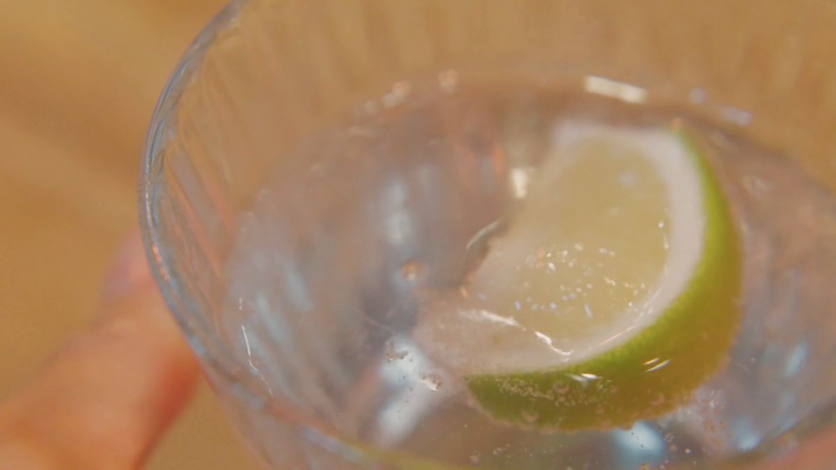 手に持ったレモンの炭酸水のグラス