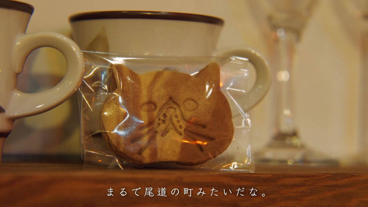 マグカップの前に置かれた猫の形の焼き菓子