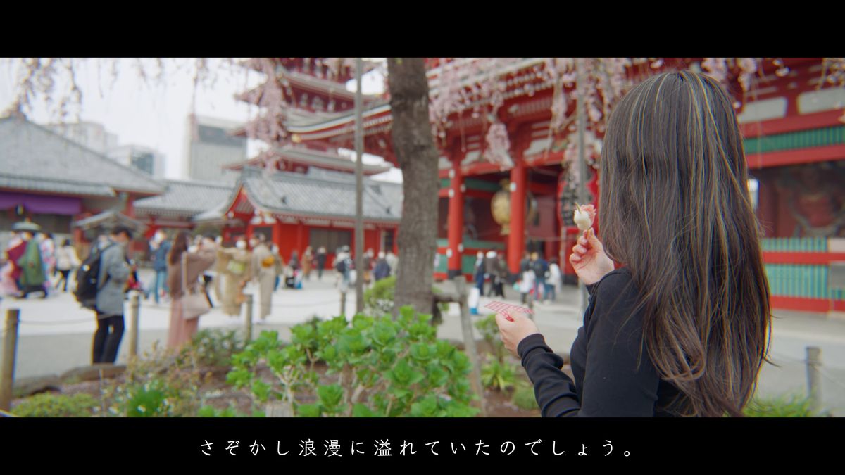 浅草寺の境内で、いちご団子を手にする後ろ姿