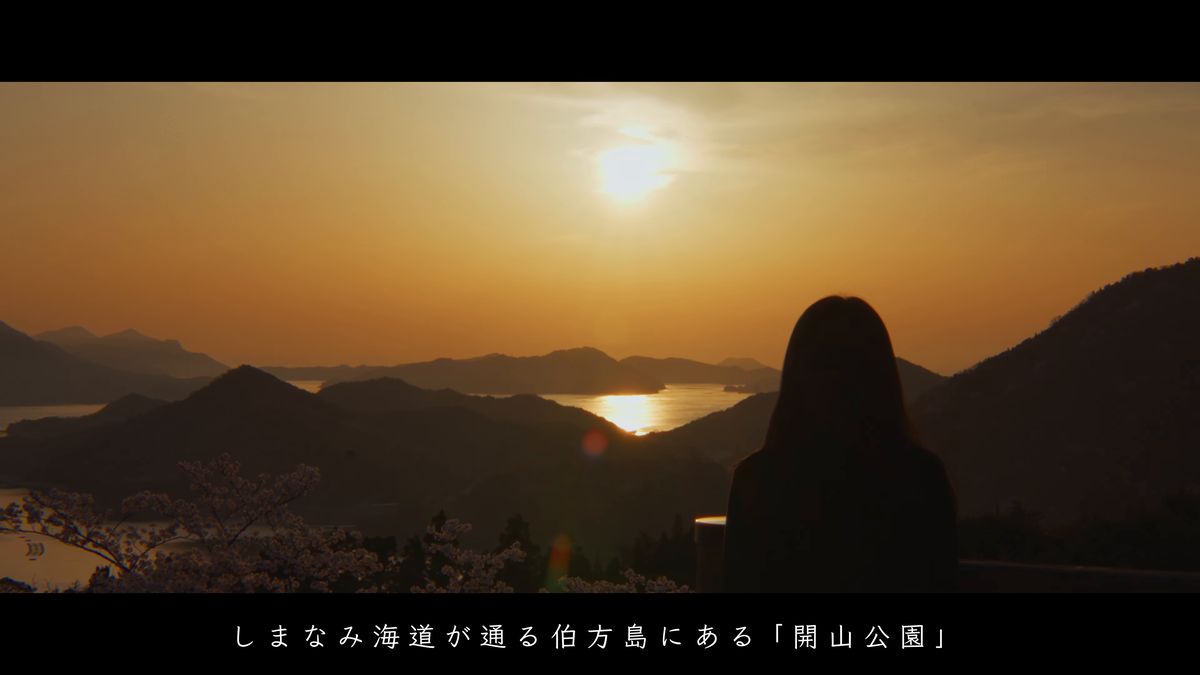 夕日と島影を眺めるシルエット