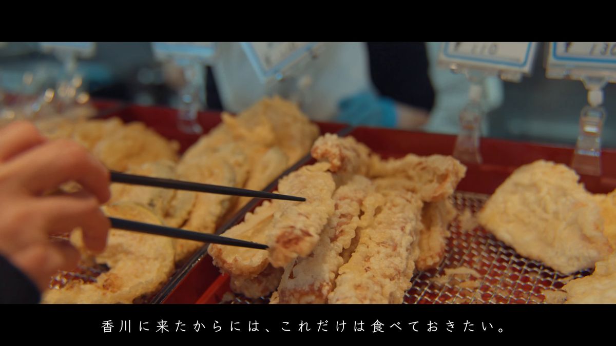 並んだ天ぷらを箸で取る手元