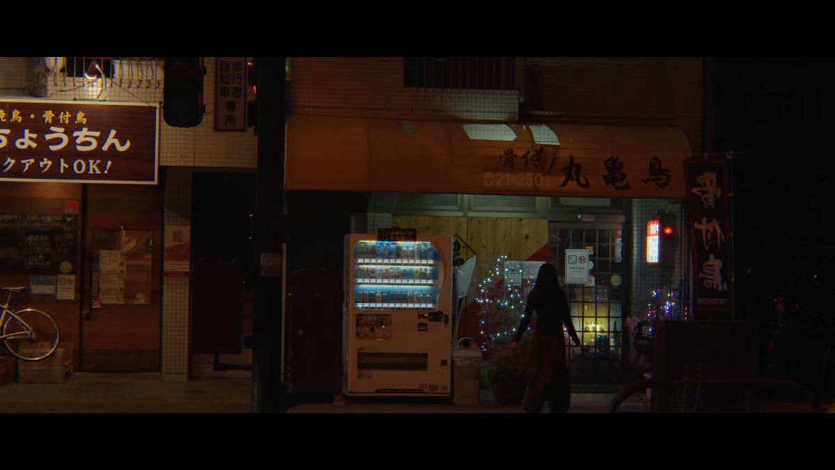 夜の通りに「骨付 丸亀鳥」の看板を掲げた店