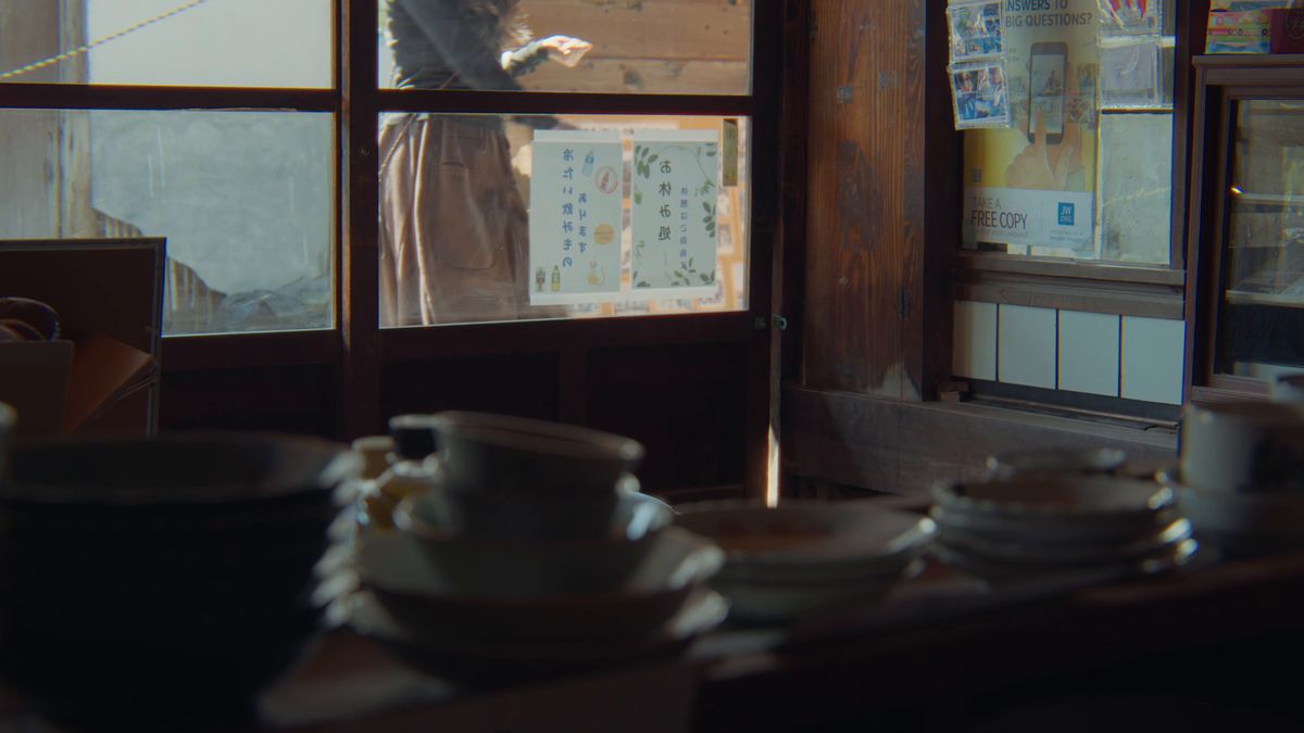 窓越しに見た「お休み処」の貼り紙と、棚の器