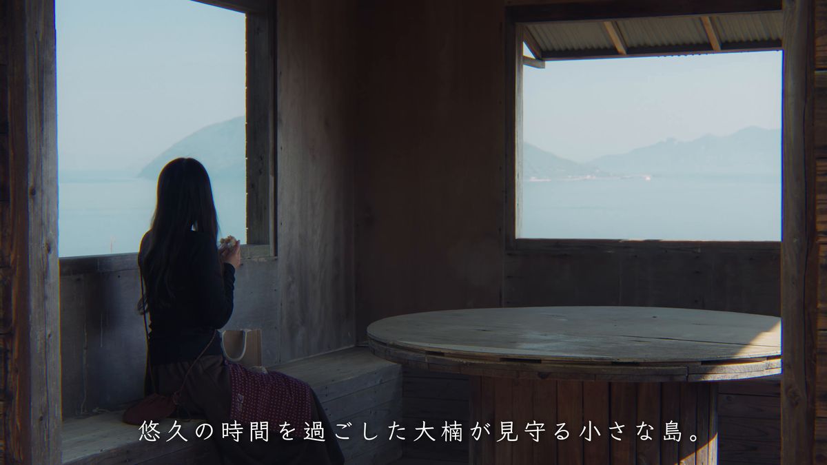 小屋の窓から海を眺める後ろ姿と丸いテーブル