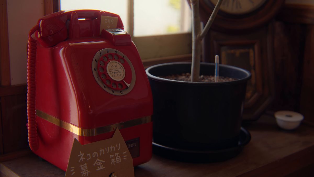ネコのカリカリ募金箱になった赤いダイヤル式電話