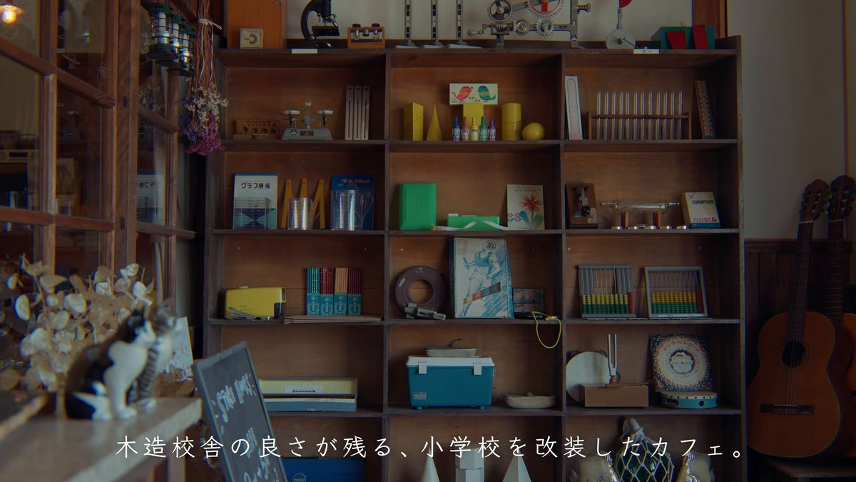 学用品や置物、ギターが並ぶ木の棚