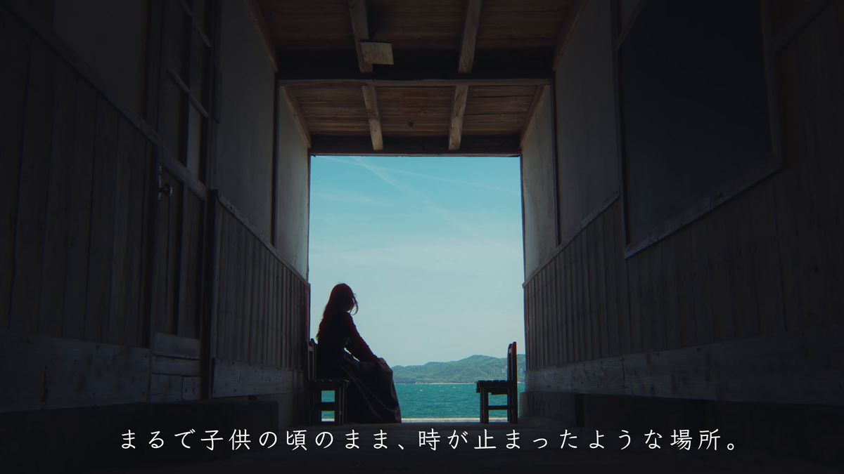 廊下の奥、海を前に椅子に座るシルエット