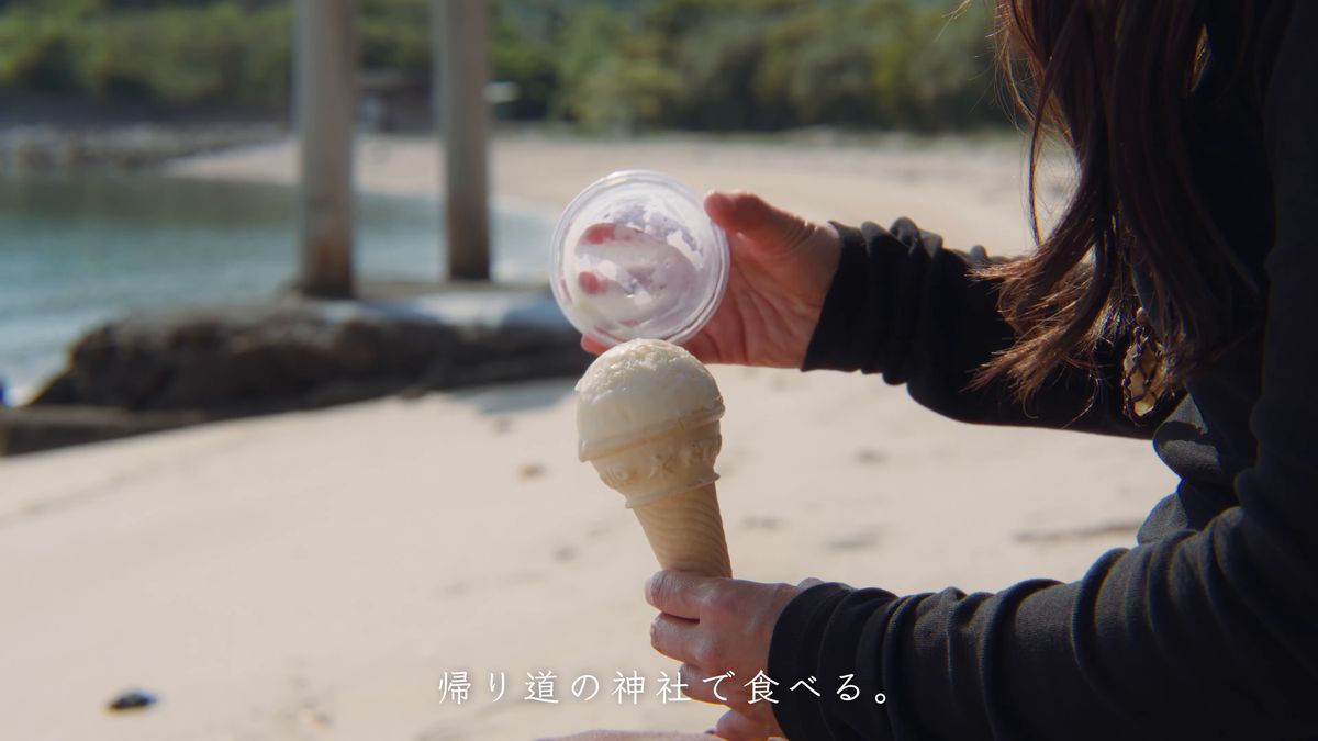 砂浜でアイスクリンを手にする手元